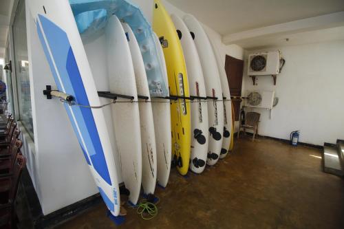 a row of surfboards lined up against a wall at Bentota Home Stay in Bentota
