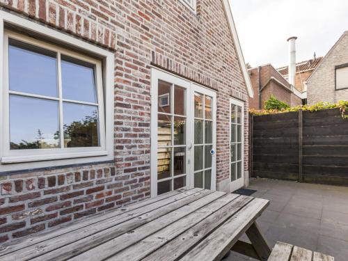 ウェーメルディンゲにあるSunny holiday home near the seaのレンガ造りの建物の外に座る木製のベンチ