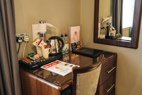 a desk in a room with a coffee maker on it at The Mount Country Manor Hotel & Golf Wolverhampton in Wolverhampton