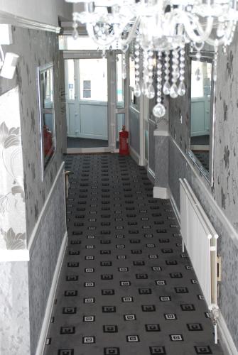 a hallway with a tile floor and a chandelier at Brincliffe Hotel in Blackpool