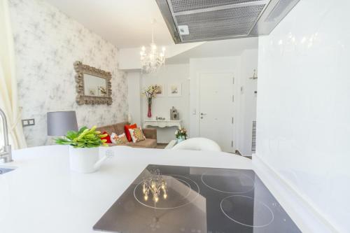 Sala de estar blanca con mesa de cristal en Cubo's Apartamento Boutique Alhaurin, en Alhaurín el Grande