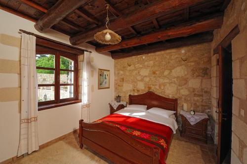 a bedroom with a bed in a stone wall at Strofilia Villas Crete in Sellía