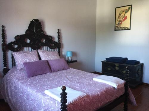 a bedroom with a bed with purple and white sheets at Alojamento de Santa Maria (near Siza Vieira's Church) in Marco de Canaveses