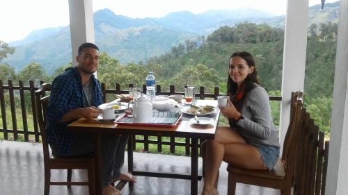 a man and a woman sitting at a table with food at Ella Repose in Ella