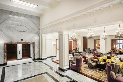 a living room filled with furniture and a large window at Grand Hotel Kempinski Riga in Riga