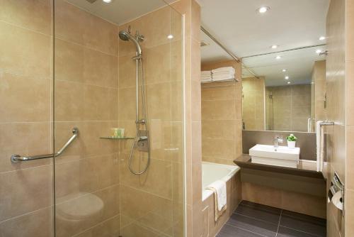 a bathroom with a shower and a tub and a sink at The Cityview - Chinese YMCA of Hong Kong in Hong Kong