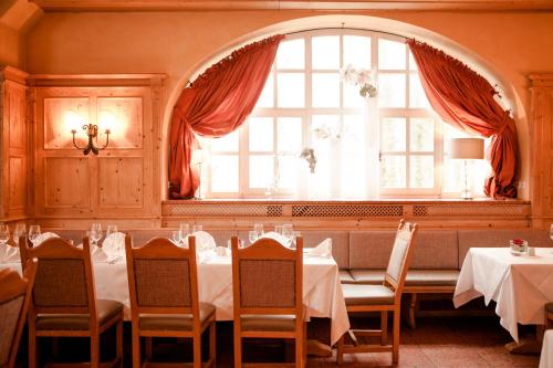 a dining room with tables and chairs and a window at Schlosshotel Grünwald in Grünwald
