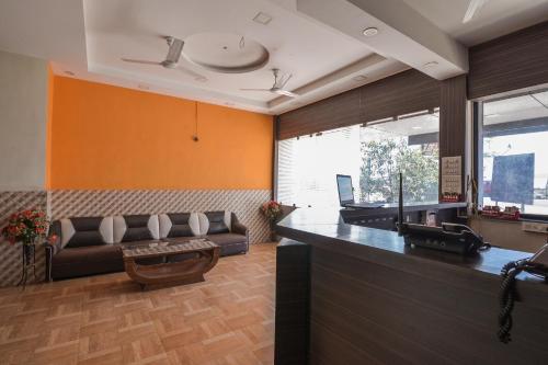 a lobby with a bar with a couch and a table at Hotel Om Palace in Lonavala