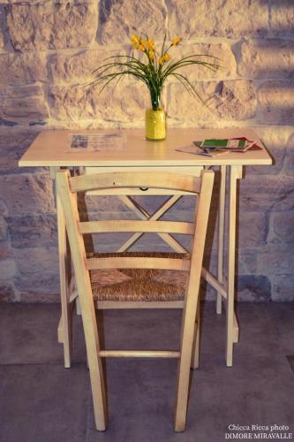 une table en bois avec un vase et des fleurs. dans l'établissement Dimore Miravalle, à Martina Franca
