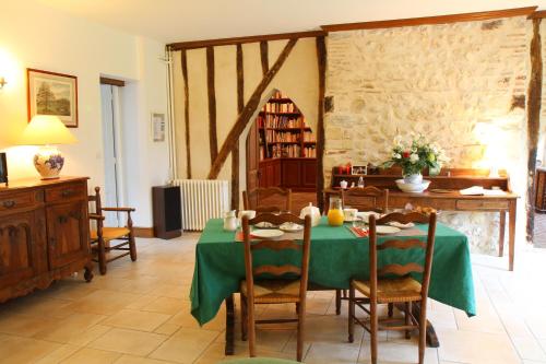 comedor con mesa verde y sillas en La Héraudière Bed & Breakfast, en Tours