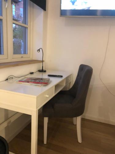 a desk with a chair and a lamp on it at BANA nr 5 in Lund