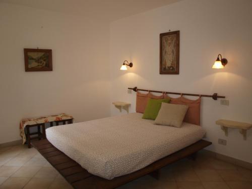 a bedroom with a bed and two lights on the wall at Villa Fralù in Mattinata
