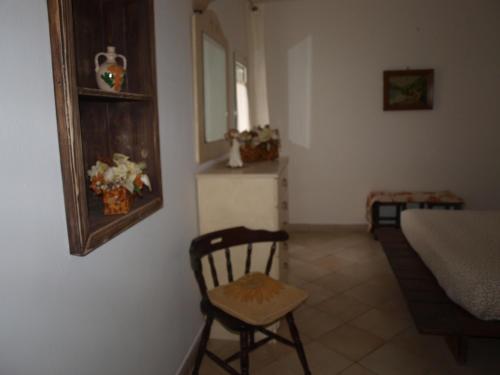 a room with a chair and a bed and a table at Villa Fralù in Mattinata
