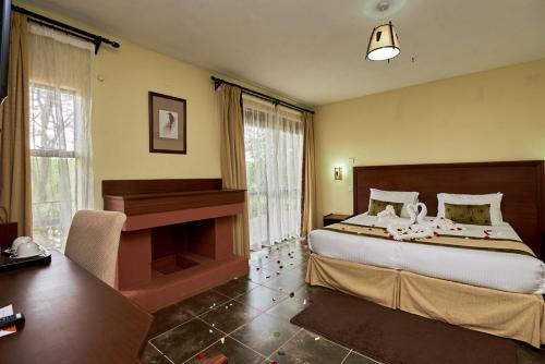 a bedroom with a large bed and a piano at Sagana Getaway Resort in Maranjua