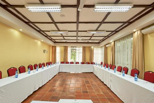 a conference room with red chairs and a long table at Sagana Getaway Resort in Maranjua