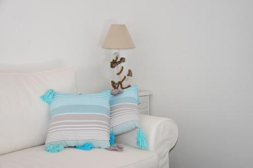 a white couch with two striped pillows and a lamp at Levantara in Jezera