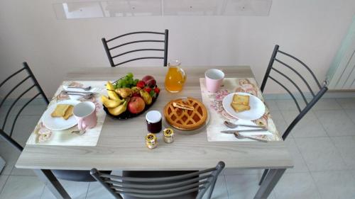 a table with a bowl of fruit and a plate of food at La Magnolia sul Lago in Campolattaro