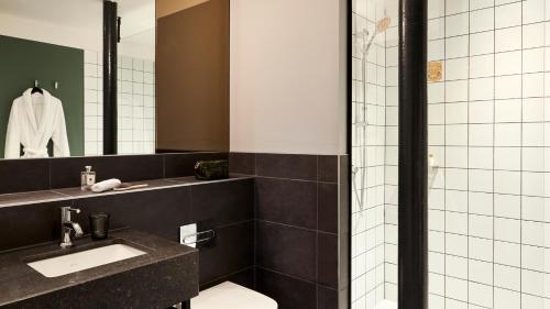 a bathroom with a toilet and a sink and a mirror at Hotel Indigo - Dundee by IHG in Dundee