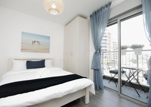 um quarto branco com uma cama e uma varanda em 2R full of charm and style at heart of Florentine em Tel Aviv