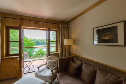 a living room with a couch and a window at Hotel Gut Klostermühle natur resort & medical spa in Alt Madlitz