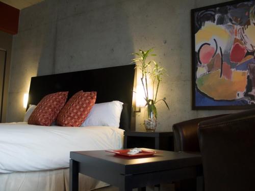 a hotel room with a bed and a table with a table at Grand Times Hotel in Quebec City