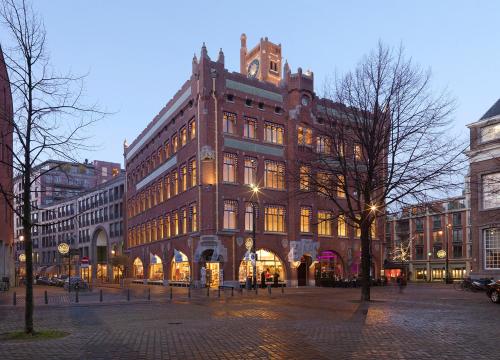 a large building on a city street at night at Berlage Hotel, BW Signature Collection in The Hague