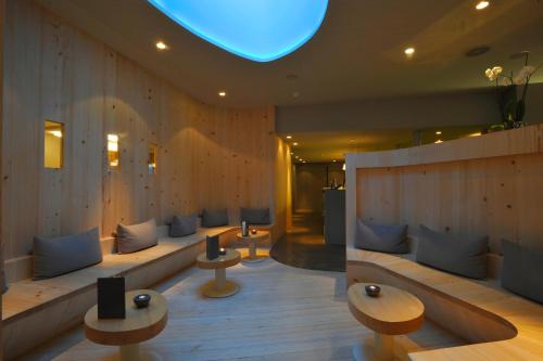 eine Lobby mit Sofas und Tischen und blauem Licht in der Unterkunft Herisau Swiss Quality Hotel in Herisau