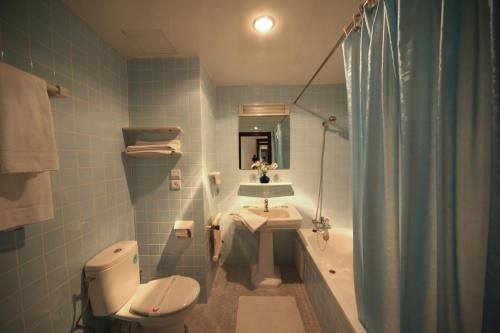 a bathroom with a toilet and a sink and a tub at Hotel Chellah in Tangier