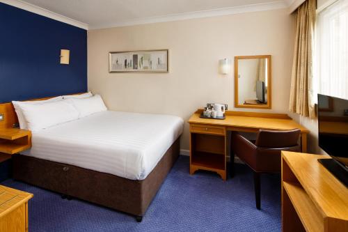 a hotel room with a bed and a desk at Mercure Bradford, Bankfield Hotel in Bradford