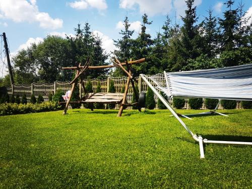 a hammock and a table in a yard at Noclegi U Dyncyka in Krajno Pierwsze
