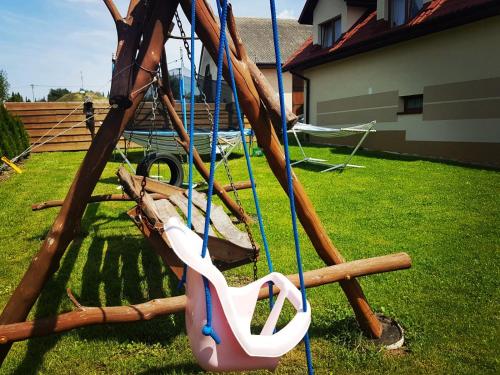 a swing with a pair of scissors on it at Noclegi U Dyncyka in Krajno Pierwsze