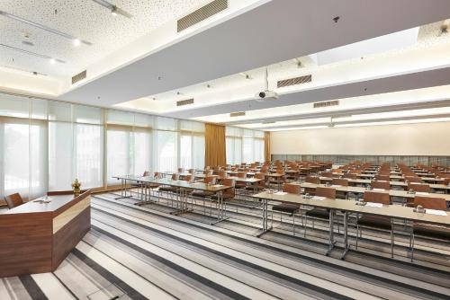 an empty lecture hall with tables and chairs at Meliá Düsseldorf in Düsseldorf