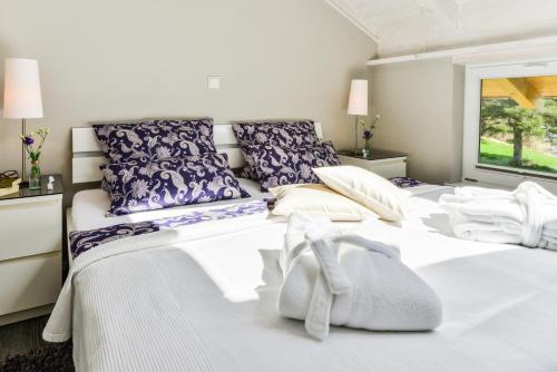 1 dormitorio con 2 camas con almohadas moradas y blancas en 5 Sterne Ferienwohnung am See, en Böbing