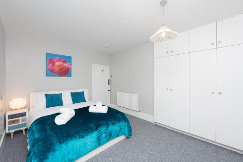a bedroom with a blue and white bed with towels on it at Sea Front Walk in Broadstairs