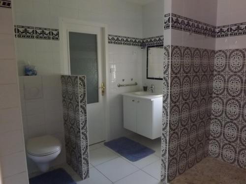 une salle de bain avec toilettes et lavabo dans l'établissement La Petite Auberge, à Comps
