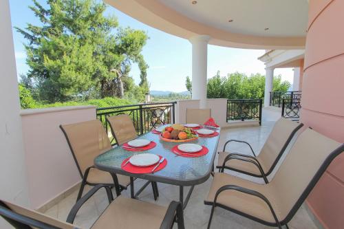 un tavolo con una ciotola di frutta su un balcone di Villa Sunshine a Città di Zante