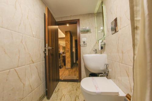 a bathroom with a toilet and a sink at Hotel Maharana Inn Chembur in Mumbai