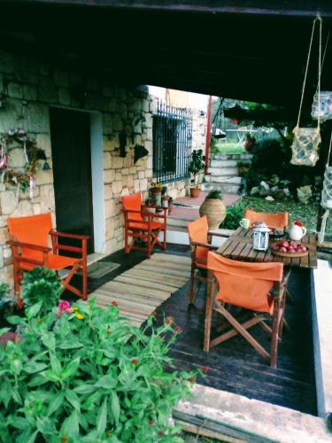 eine Holzterrasse mit Stühlen und einem Tisch in der Unterkunft Spiti me thea & elliniko chroma in Nea Moudania