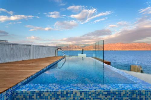 a swimming pool on the deck of a house on the water at Herbert Samuel The Reef Eilat in Eilat