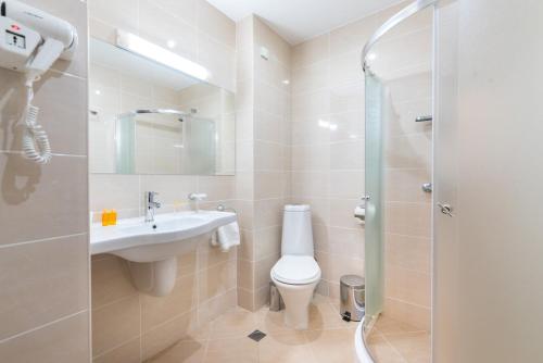 a bathroom with a toilet and a sink and a shower at Hotel Zara in Bansko