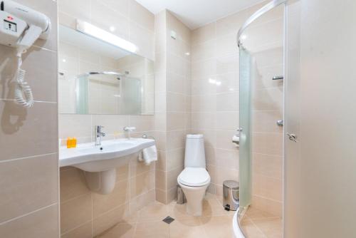 a bathroom with a toilet and a sink and a shower at Zara Hotel in Bansko