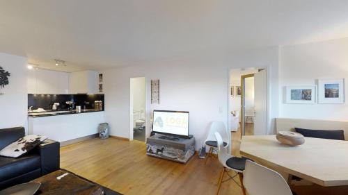 a living room with a table and a tv in it at Arsa 26 in Silvaplana