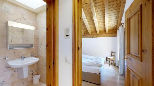 a bathroom with a sink and a bed in a room at Corvatsch 3/47 in Silvaplana