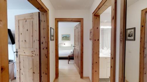 a hallway with wooden doors and a bedroom at Polaschin E12 in Sils Maria