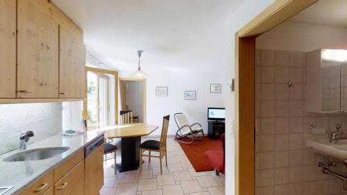 - une cuisine avec un évier et une table dans une chambre dans l'établissement Prüveda A0.5, à Silvaplana