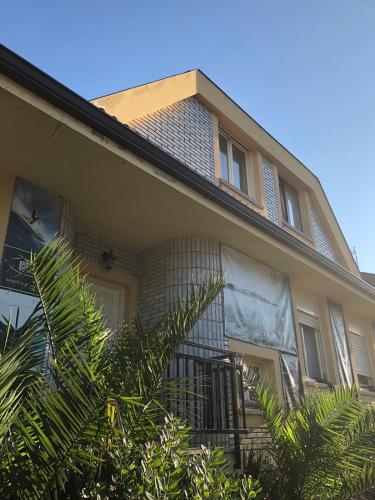 una casa bronceada con balcón y árboles delante de ella en La Mies del Marqués en Santoña