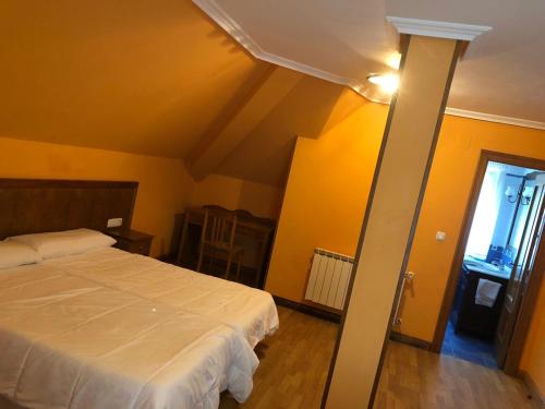 a bedroom with a white bed and yellow walls at La Mies del Marqués in Santoña