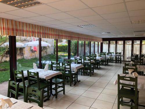 un comedor con mesas, sillas y ventanas en La Mies del Marqués, en Santoña