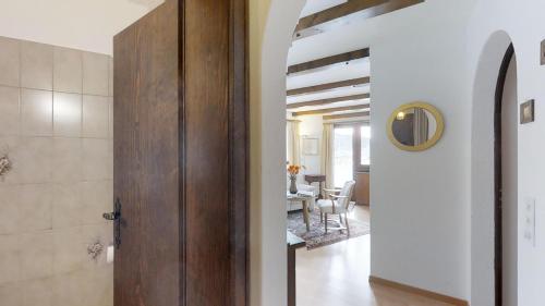 a hallway with a wooden door and a dining room at Polaschin in Celerina