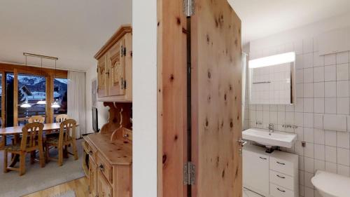 シルヴァプラーナにあるFlurina 43の木製のドア、シンク、テーブル付きのキッチンが備わります。